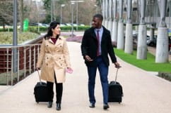 Kontakt für Nicht-Kunden: Zwei Personen laufen nebeneinander mit Koffern