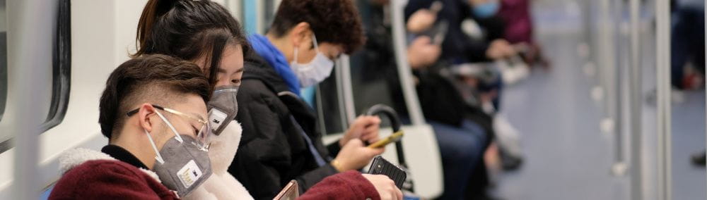 Pandemielösungen für Mitarbeiter: Personen sitzen in einer Bahn und tragen Masken