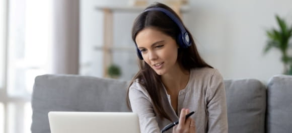 Digitales Lernen: Person sitzt mit Kopfhörern vorm Laptop